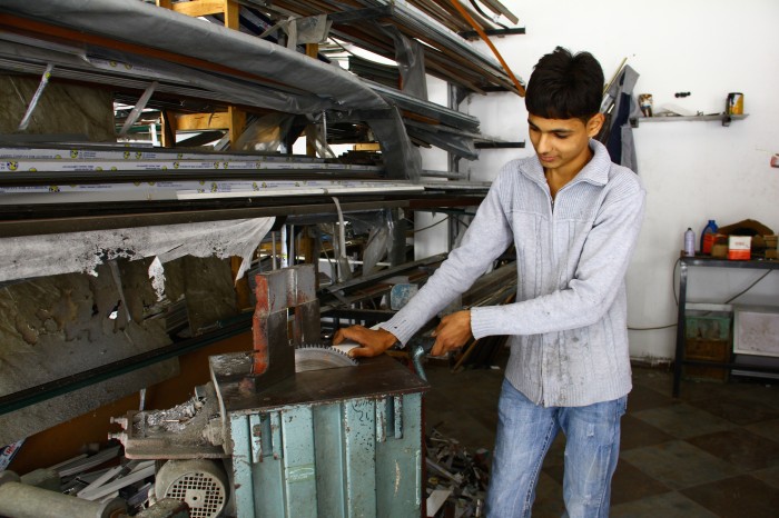 Mohammad Aldahdouh (19) is now employed full time in an aluminium workshop making kitchen units thanks to the NECC's job creation scheme which he participated in. Sabeel-Kairos/Charlotte Marshall